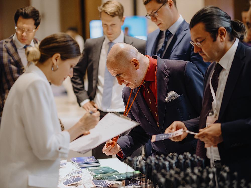 До начала деловой программы остается меньше часа — гости регистрируются, забирают бейджи и переводчики.