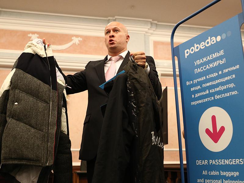 Авиакомпания «Победа» подала иск в Верховный суд к Минтрансу и Минюсту. Лоукостер просил частично отменить действующие нормы перевозки бесплатной ручной клади, которые позволяют сверх нормы 5 кг брать в салон дамские сумочки, рюкзаки, деловые костюмы и верхнюю одежду. Административная коллегия ВС, а затем и апелляция отказались удовлетворять требования истца. На фото глава авиакомпании Андрей Калмыков демонстрирует, что пассажиры пытаются пронести в салон самолета.