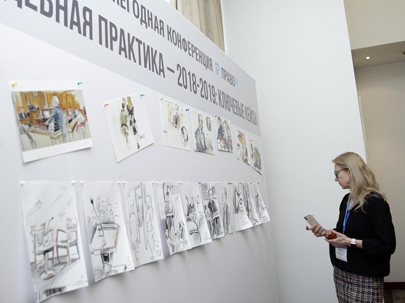 Участники и гости конференции изучают рисунки.