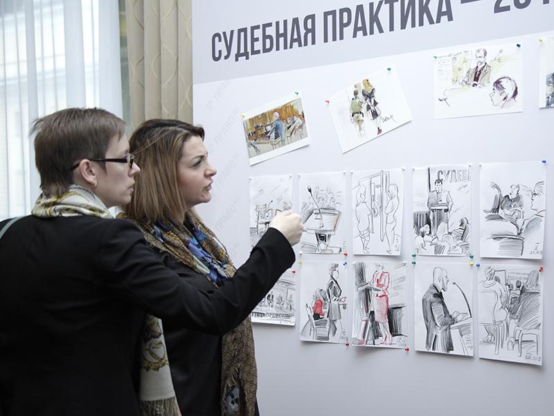 Участники и гости конференции изучают рисунки.