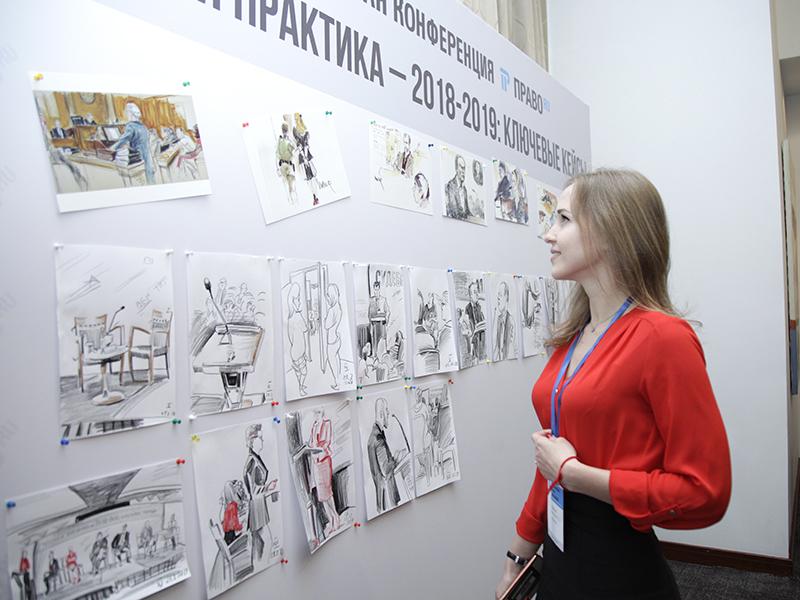 Участники и гости конференции изучают рисунки.